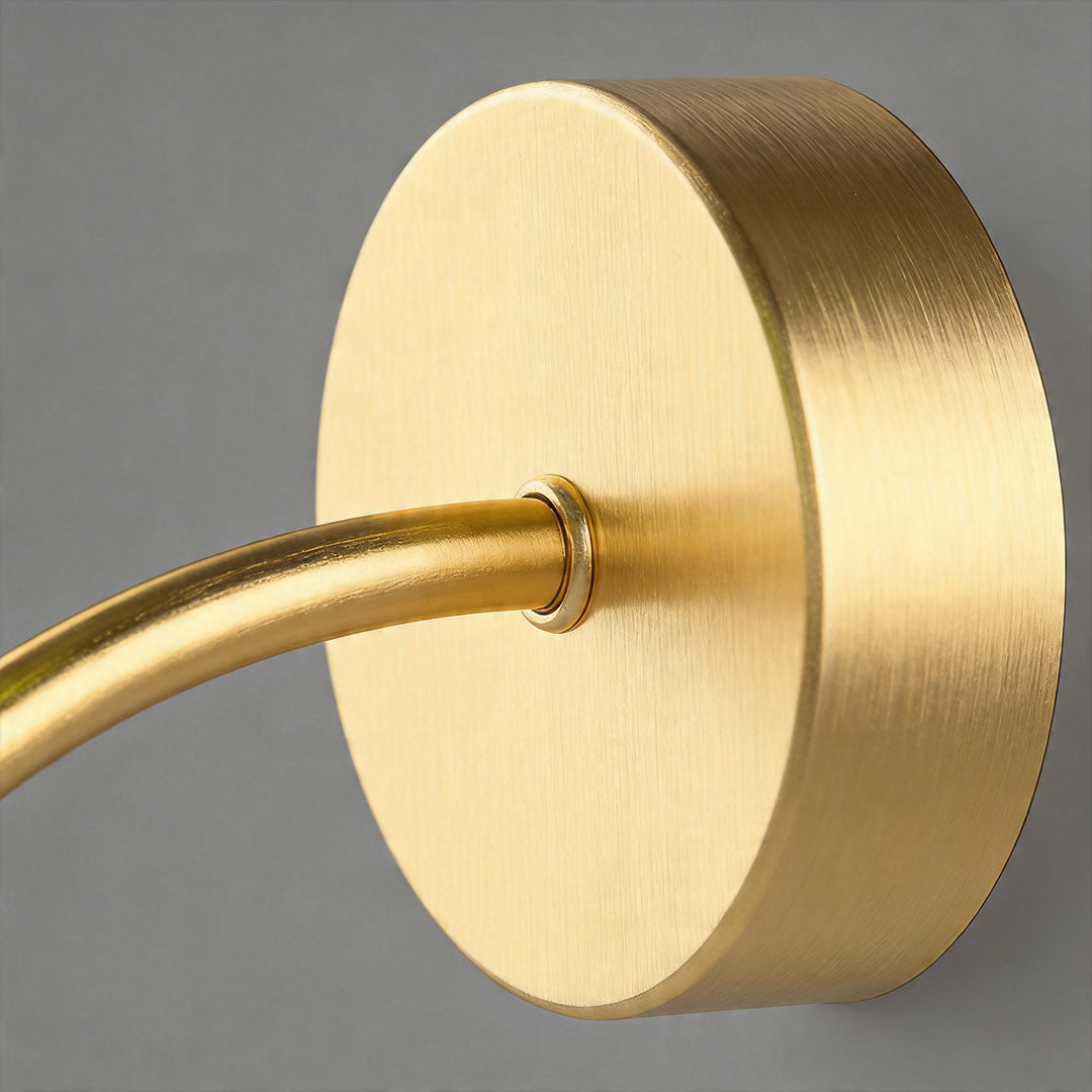 Close-up of brass wall mount for stained glass wall light with curved arm detail.