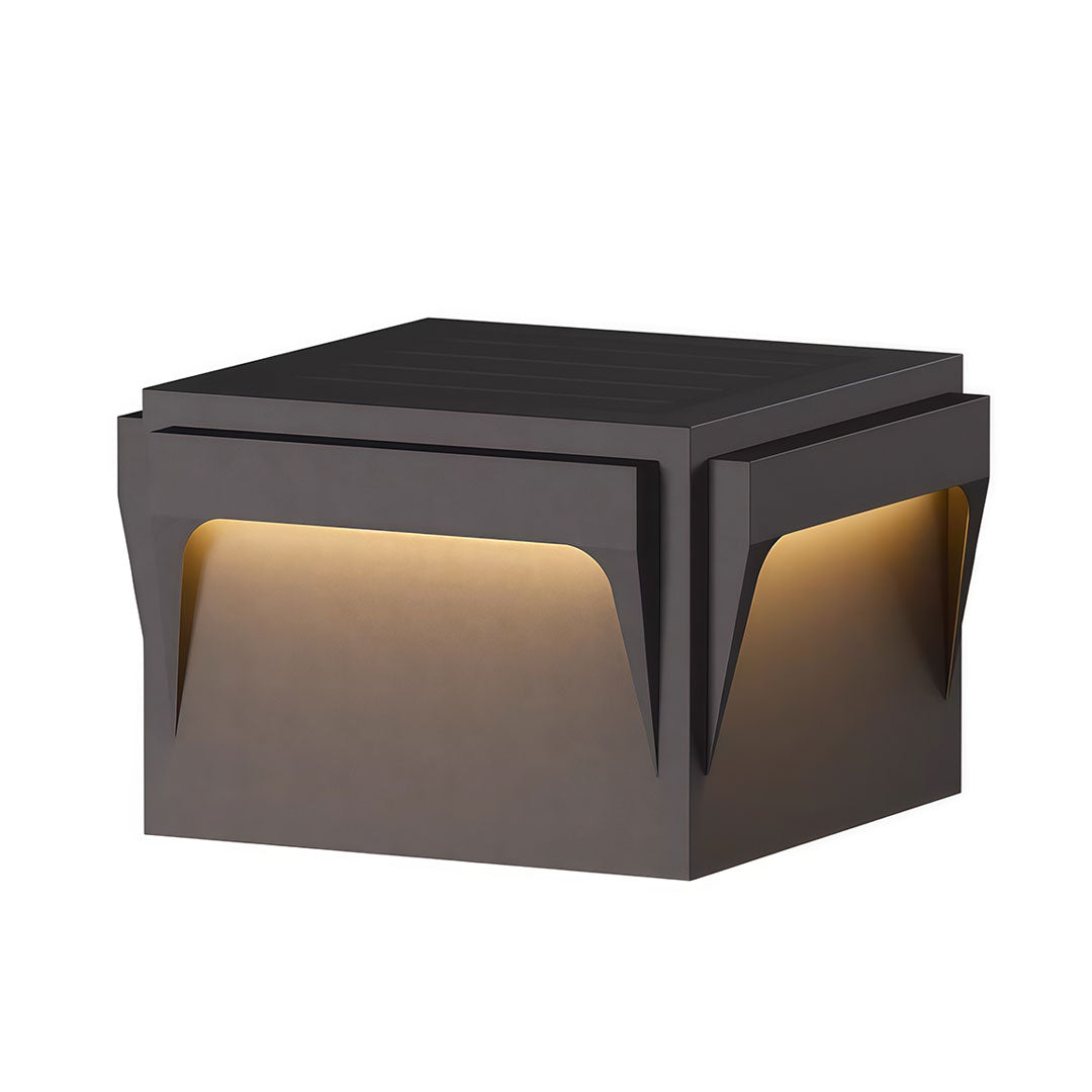Stainless steel outdoor pillar light with a modern, geometric shape and warm glow.