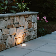 Black cylindrical ground light housing with cutout design for recessed landscape lighting installation