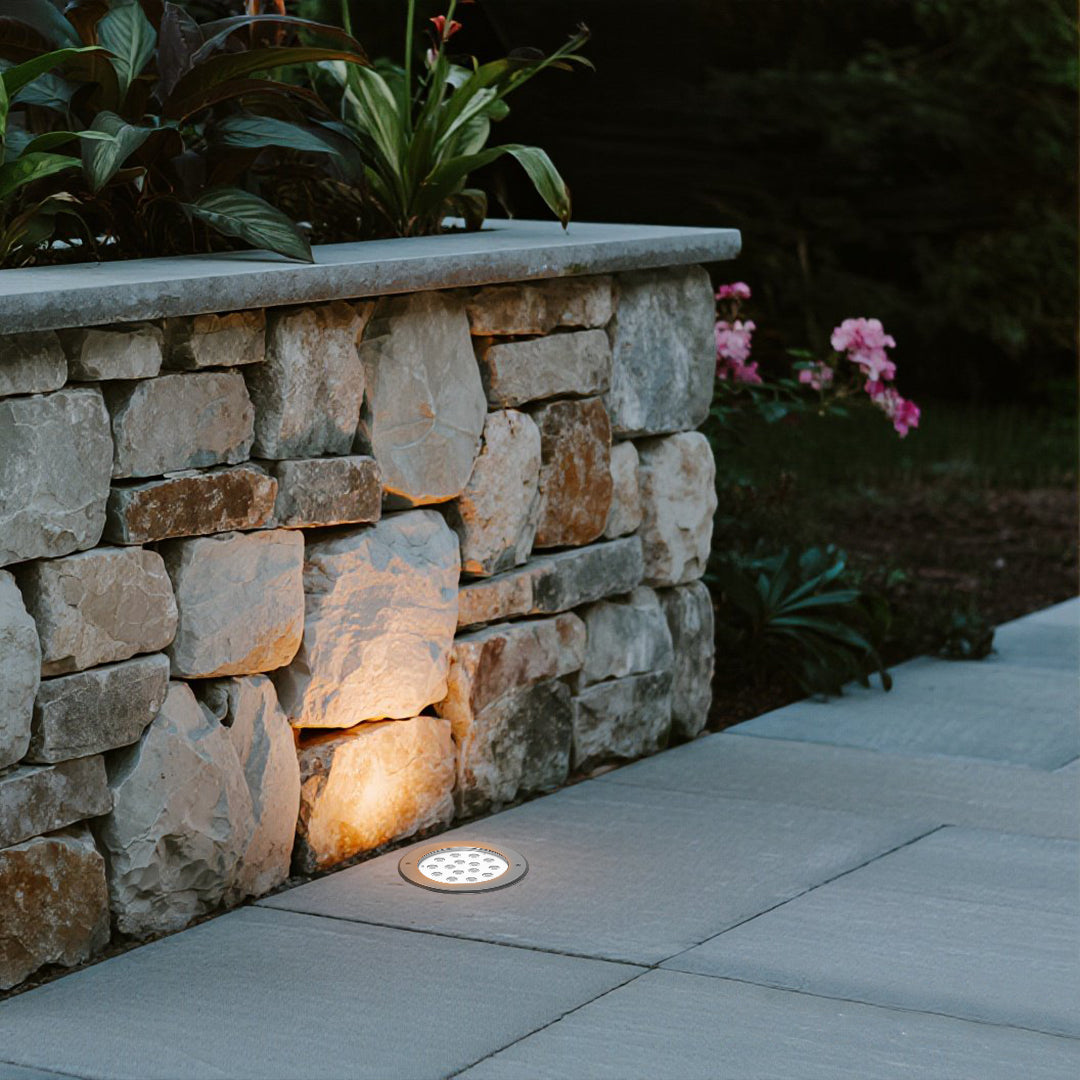 Black cylindrical ground light housing with cutout design for recessed landscape lighting installation