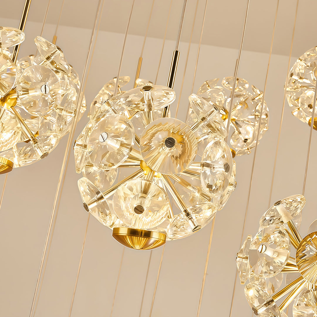 Close-up of staircase crystal chandelier ball showing fine cut and gold suspension detail.