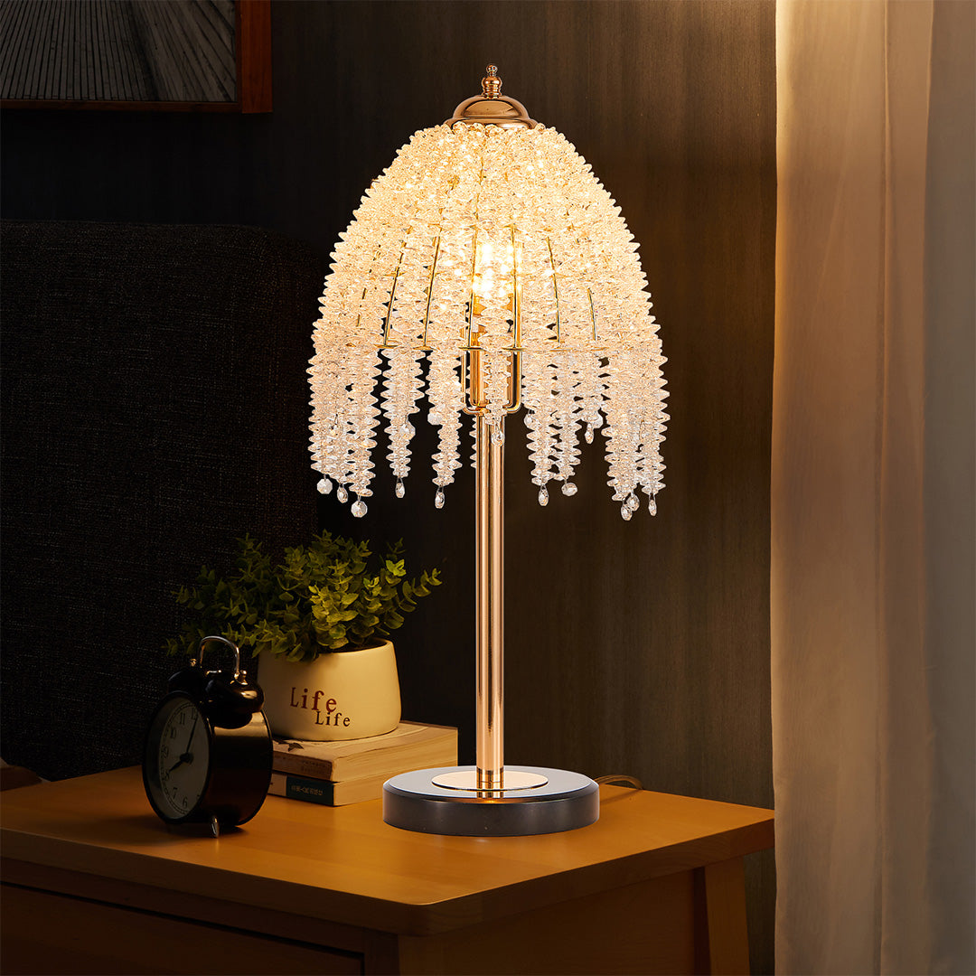 Statement gold bedside table lamp with glass shade chandelier influence on wooden nightstand creating dramatic lighting effect.