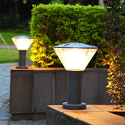 Conical outdoor light fixture mounted on stone surface creating upward illumination