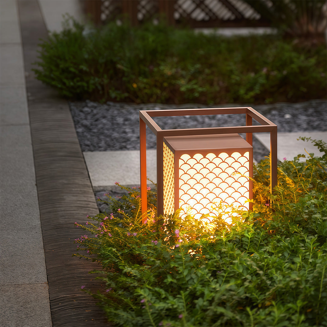 Bollard lighting along a stone pathway, creating an elegant outdoor atmosphere with its unique pattern design.