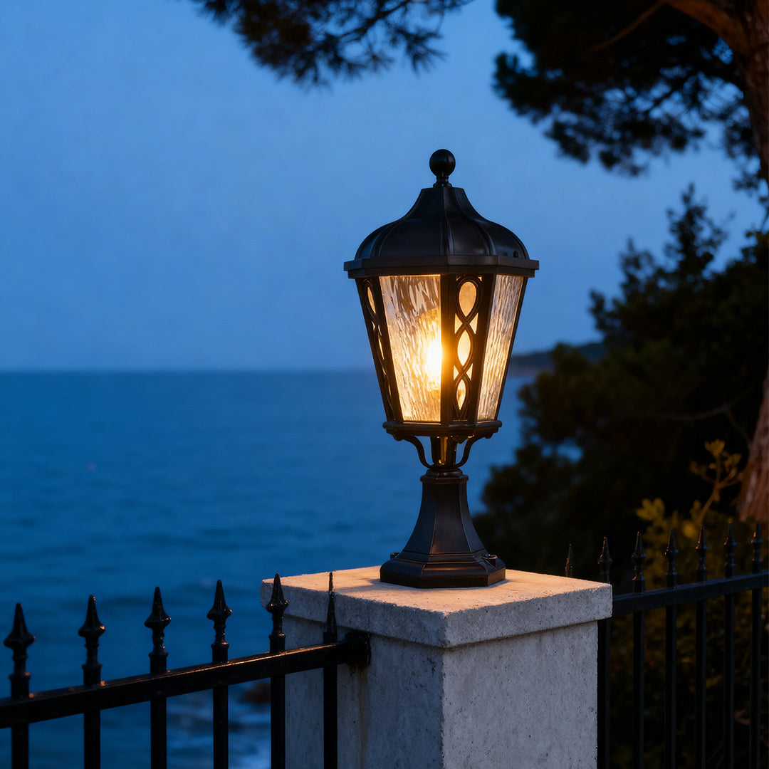 Black post light beside a stone pillar, elegant and functional outdoor lighting fixture