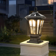 Classic black stone pillar light fixture with lantern-style design installed on outdoor stone column at night.