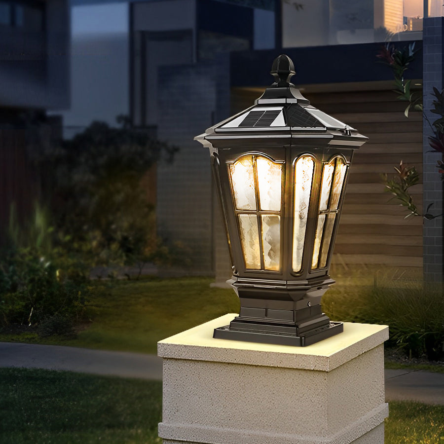 Classic black stone pillar light fixture with lantern-style design installed on outdoor stone column at night.
