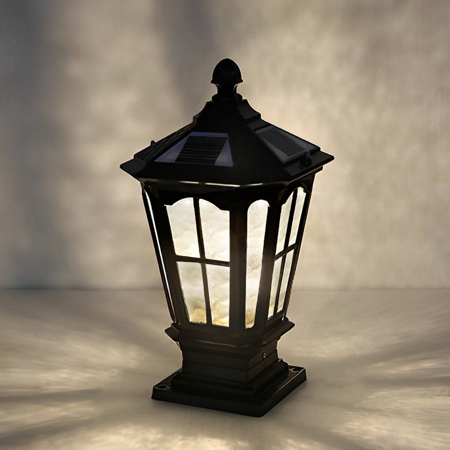 Matte black stone pillar light fixture with classic lantern silhouette photographed against neutral background.