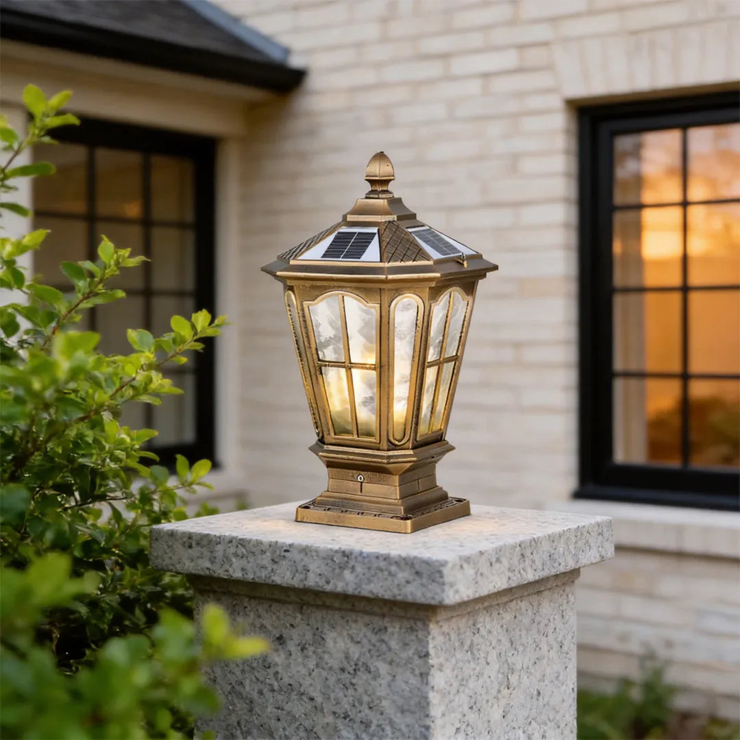 Stone pillar light fixture placed on a square stone column beside a home exterior with black-framed windows.