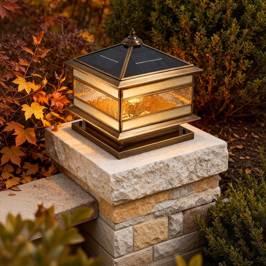 Stone pillar solar light installed on a garden column with warm illumination at dusk.