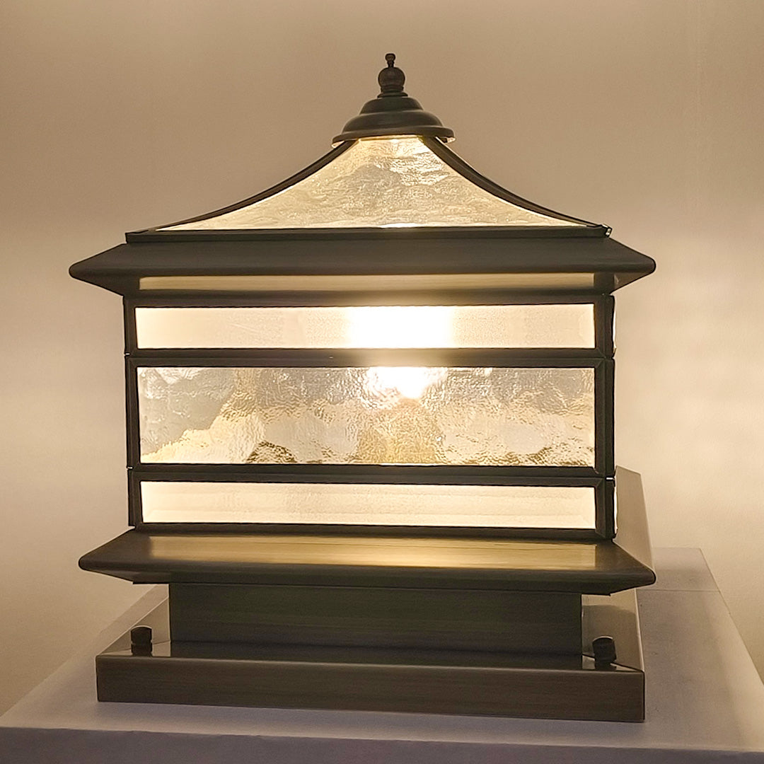 Square stone pillar solar light with textured glass panels turned on indoors.