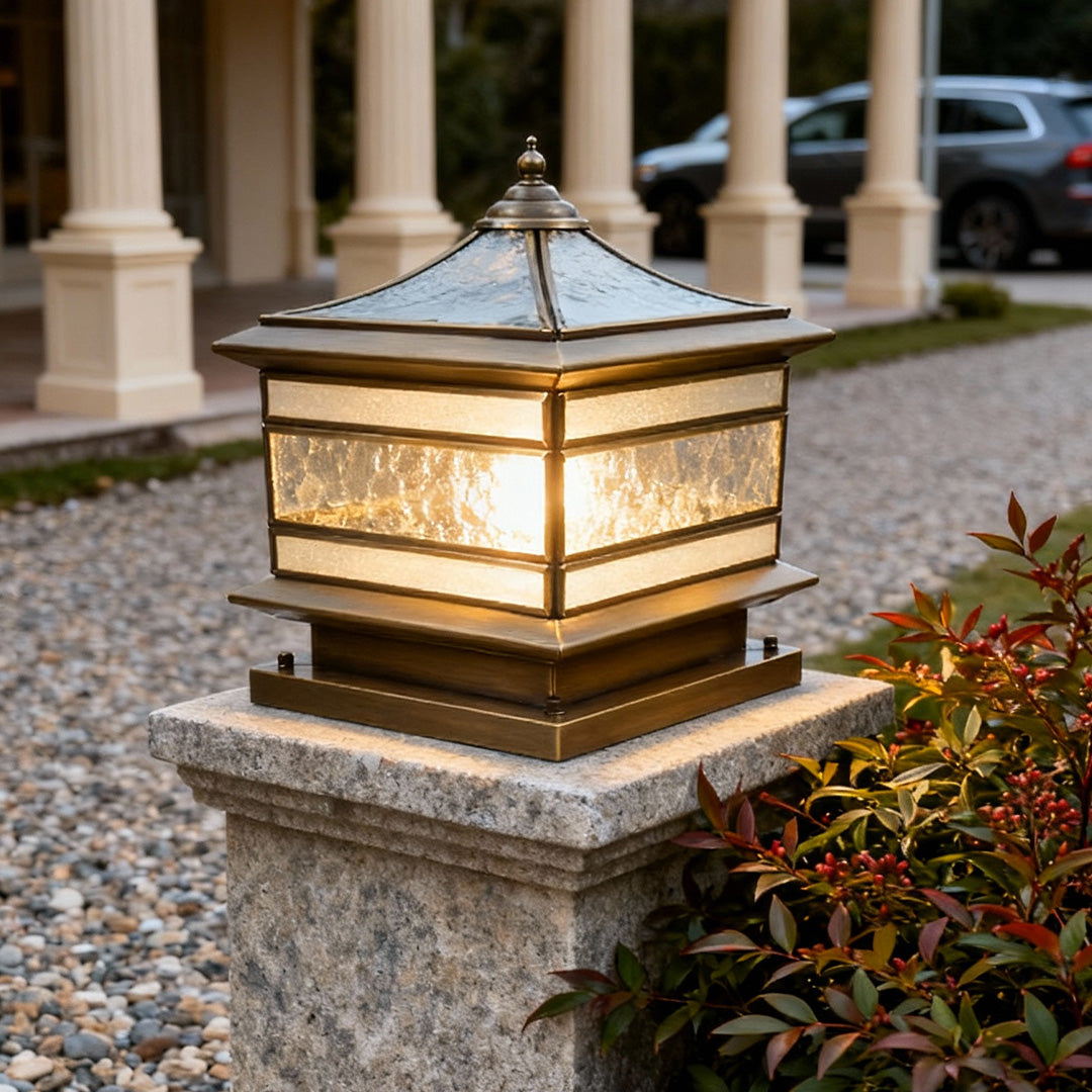 Outdoor stone pillar solar lights illuminating a gravel pathway beside a porch.
