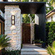 Contemporary unique outdoor wall lighting installed on a stone pillar, enhancing the garden walkway.