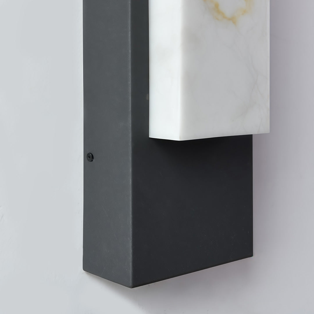 Stone texture wall light with a black finish, providing ambient light near a window.