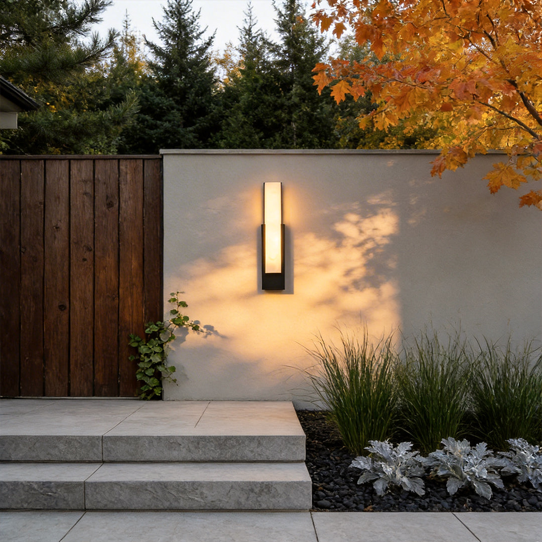 Stone texture wall light with a sleek rectangular design, illuminating a modern house entrance.