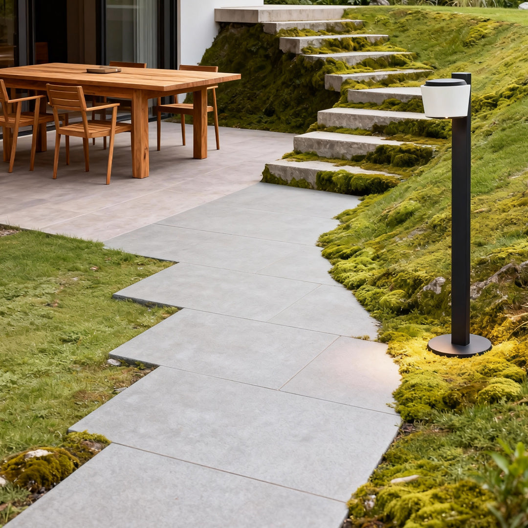 Garden lights path illuminating a curved stone walkway leading to an outdoor seating area.