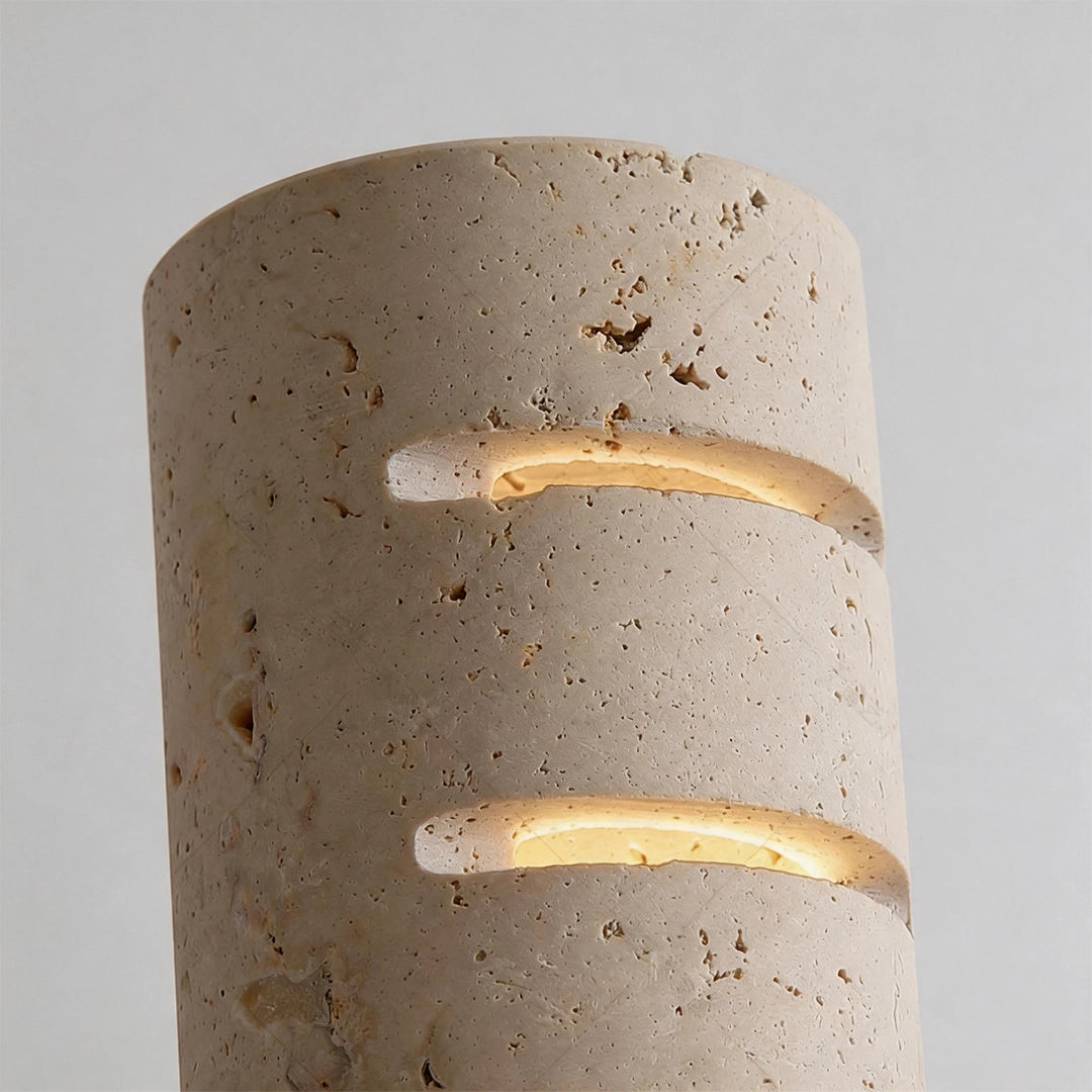 Stone wall light close-up showing the textured stone surface and layered glowing cutout bands.