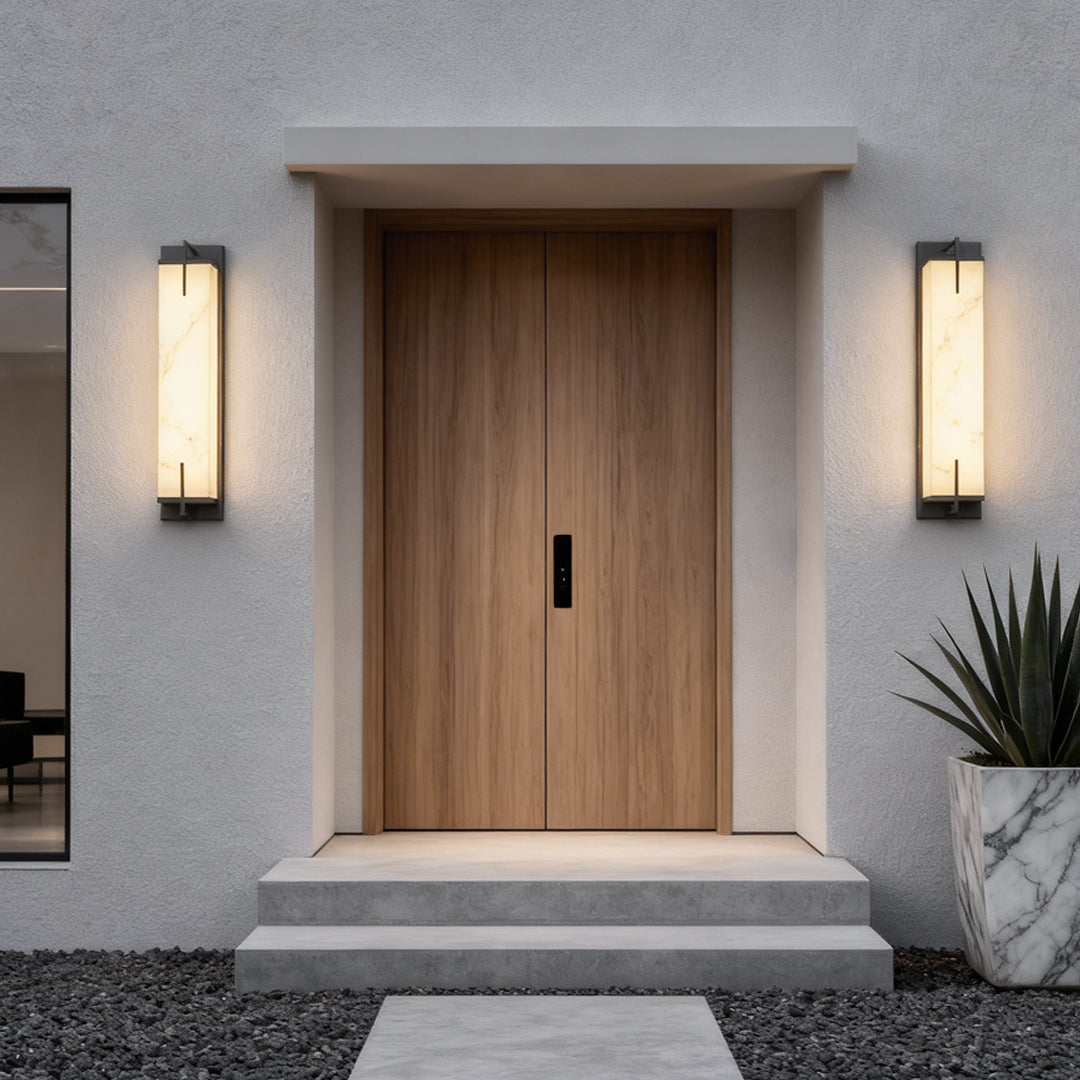 Stone wall sconce lighting installed beside a wooden door, providing modern and elegant illumination.