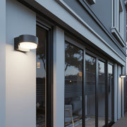 Contemporary black lights for outdoor wall installed along storefront windows providing warm illumination.