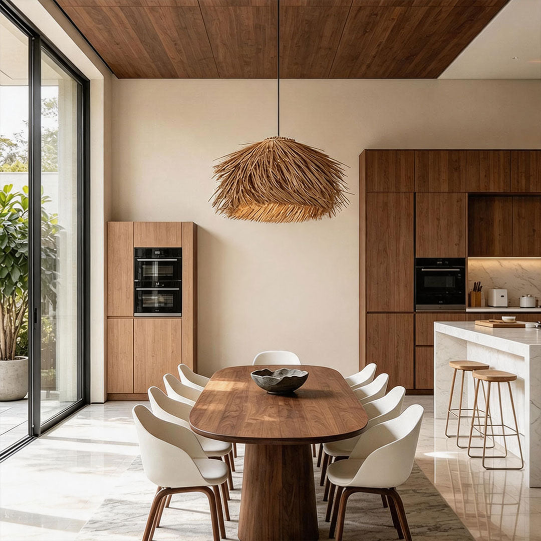 Straw pendant light suspended above a round dining table in a contemporary dining room with wood cabinetry.