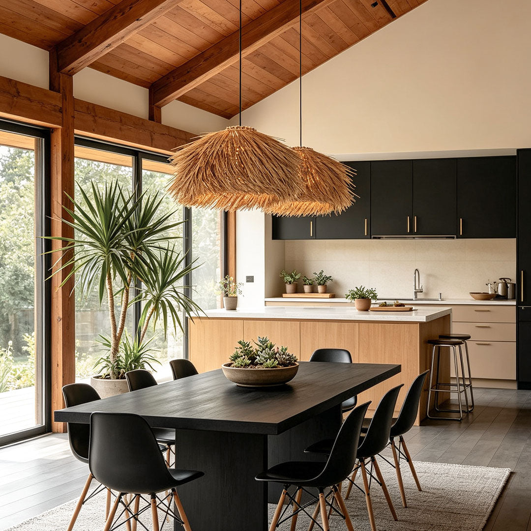 Straw pendant light hanging above a black dining table in a warm kitchen and dining space with wood beams.