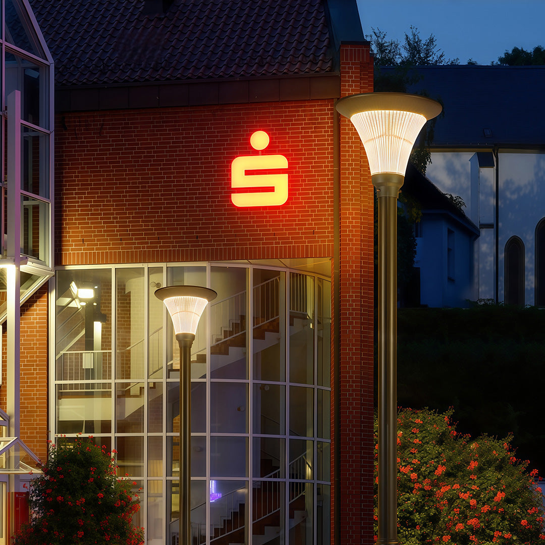 Streetlight post shining bright in the evening, enhancing visibility along the road.