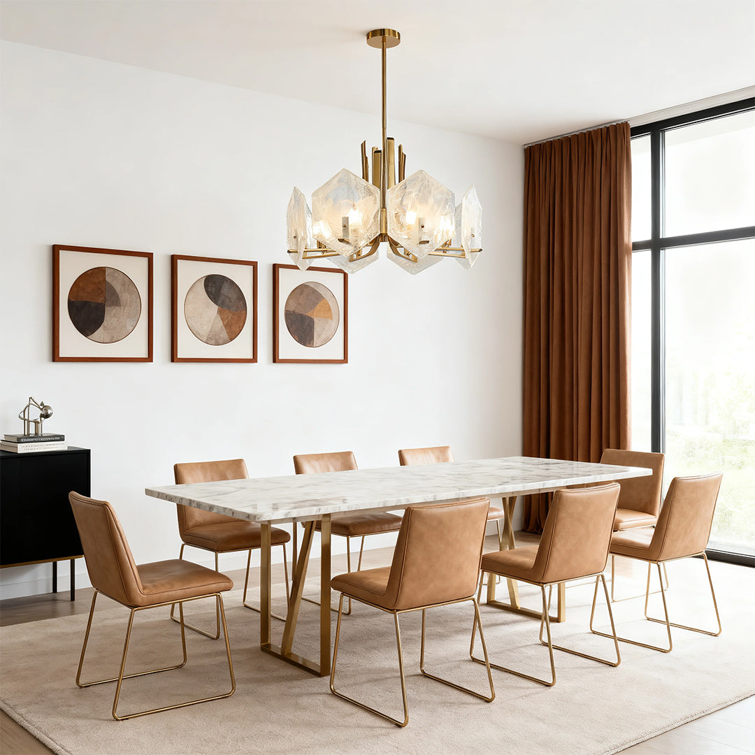 Stunning gold geometric chandelier with large, irregular crystal forms suspended over a long white marble dining table.
