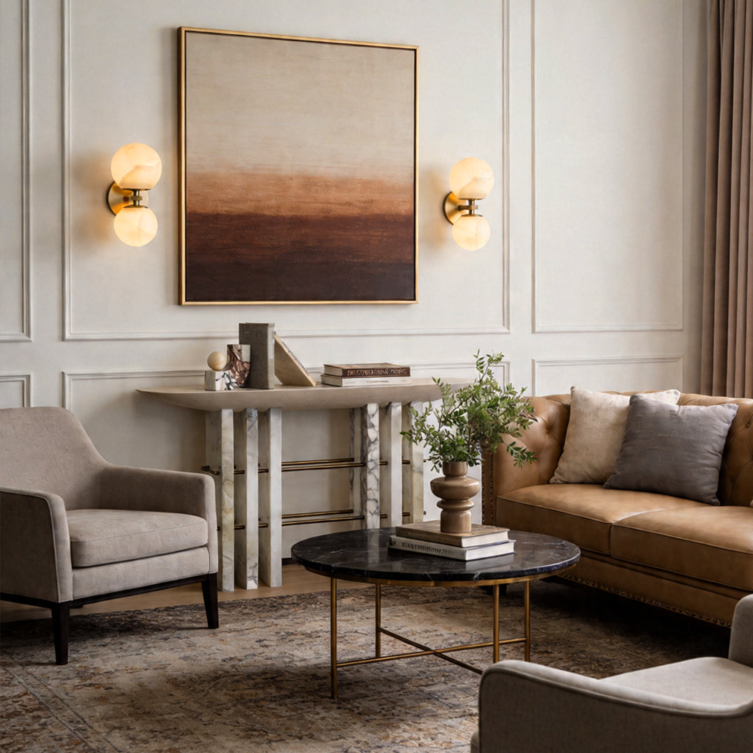 Stunning globe wall lights flanking abstract art in a modern lounge with leather sofa décor.