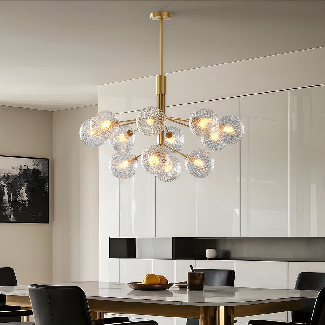 Stunning luxury modern chandeliers with multiple glass spheres, hanging above a dining table in a contemporary space.