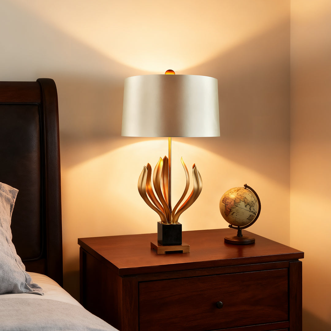 Vintage gold metal table lamp with sculptural base and beige lampshade in a chic living room