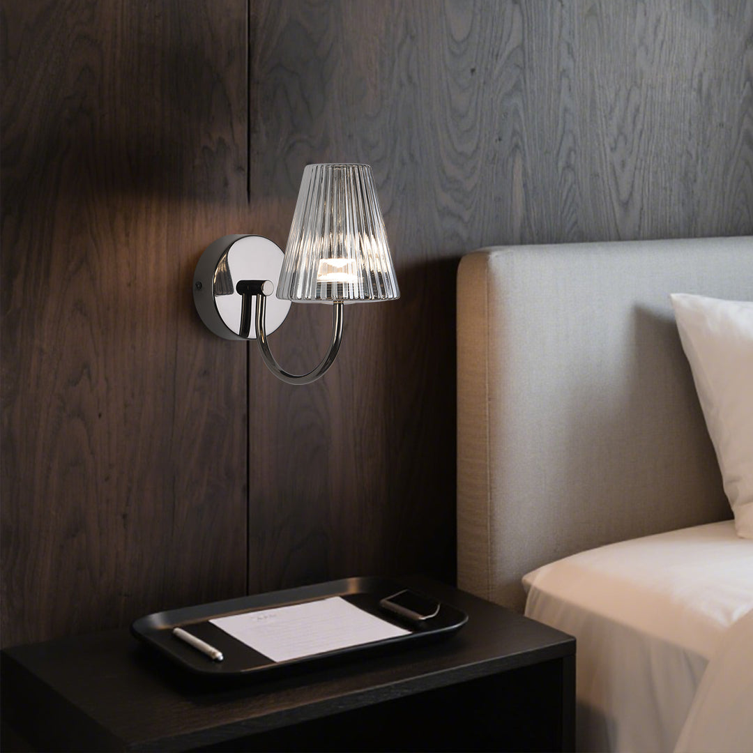 Stylish bedroom lighting with wall-mounted lamp providing ambient illumination beside white bedding