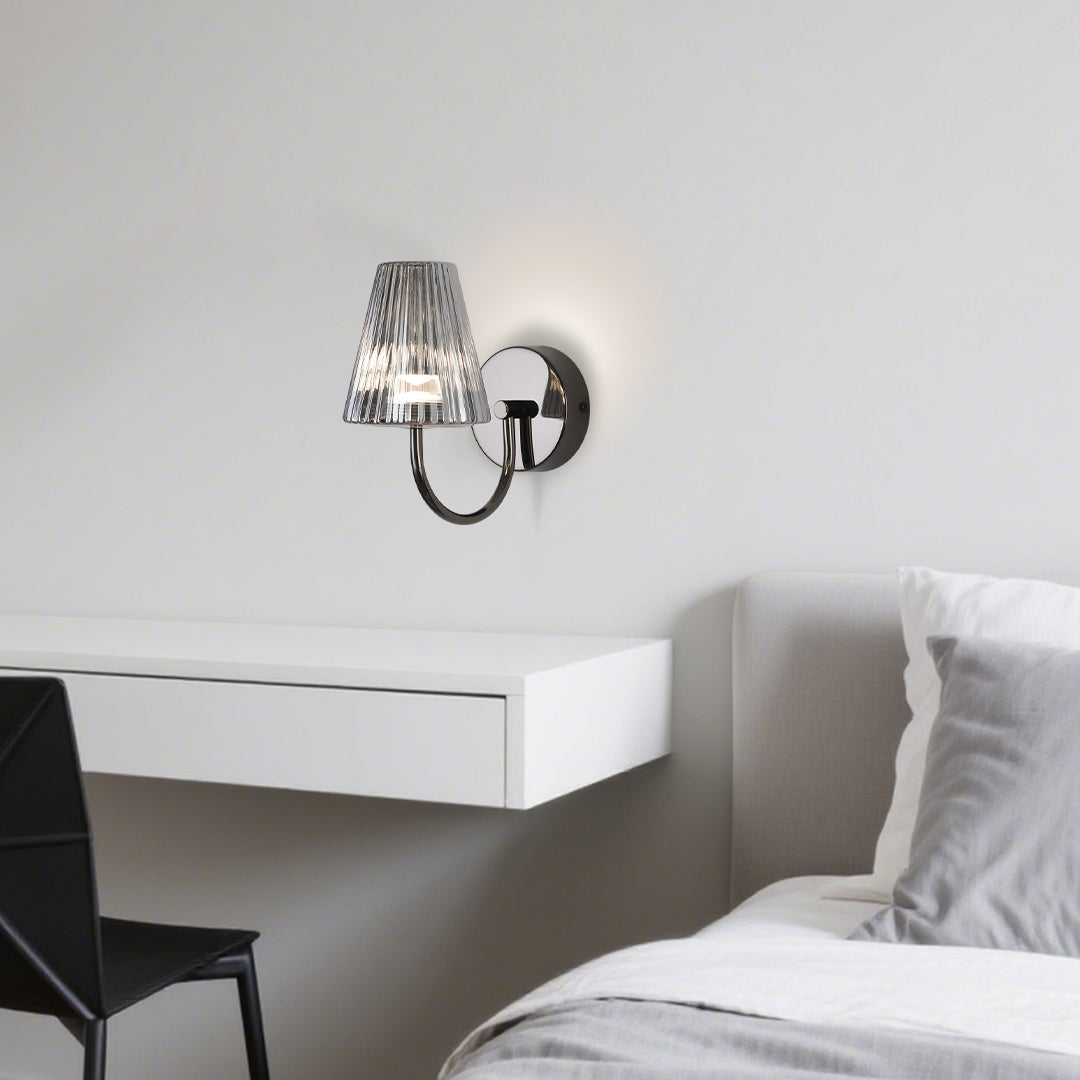 Stylish bedroom lighting with wall-mounted lamp providing ambient illumination beside white bedding