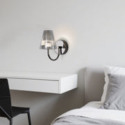 Stylish bedroom lighting with wall-mounted lamp providing ambient illumination beside white bedding