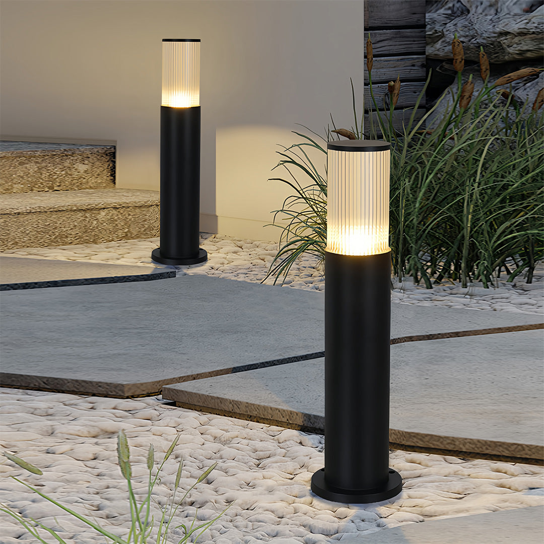 Stylish bollard path light set enhancing safety and ambiance on a gravel walkway and stone steps.