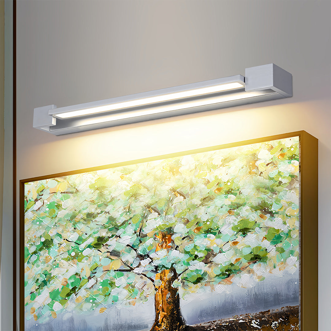 Stylish chrome bathroom vanity light providing warm illumination above framed nature photography