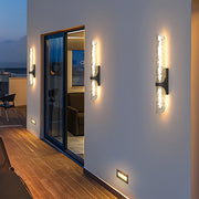 Stylish contemporary black outdoor wall lights with bubble glass illuminating a modern balcony wall.