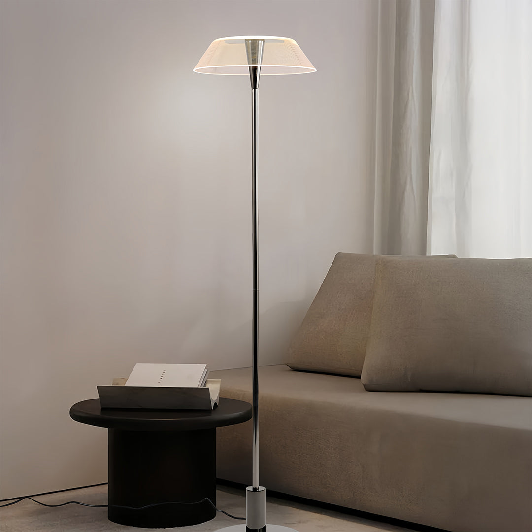 Stylish floor lamp with a white translucent shade placed beside a sofa