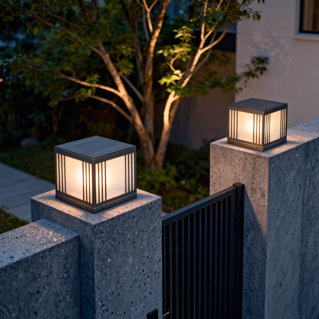 Stylish gate pillar solar light casting a gentle glow on a garden wall during evening hours.