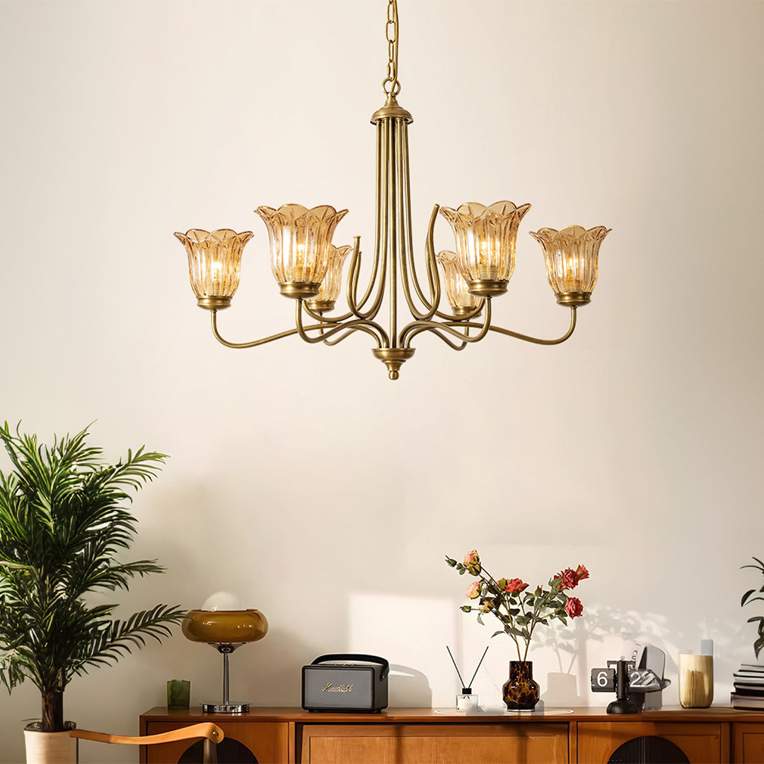 Gold glass chandelier illuminating modern dining space with warm lighting and contemporary furnishings