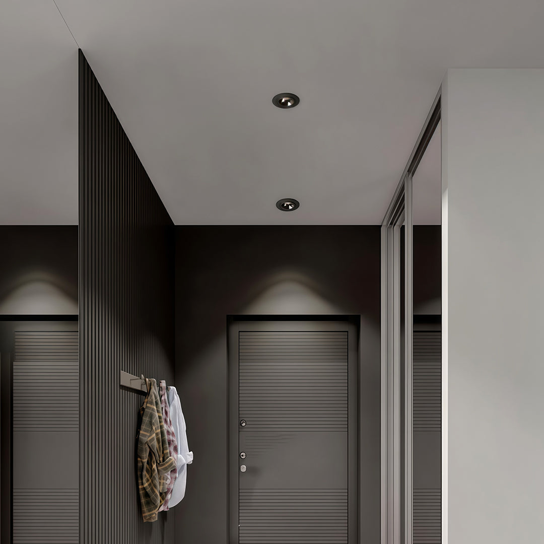 Stylish hallway featuring directional recessed downlight fixtures angled towards a dark slatted accent wall.