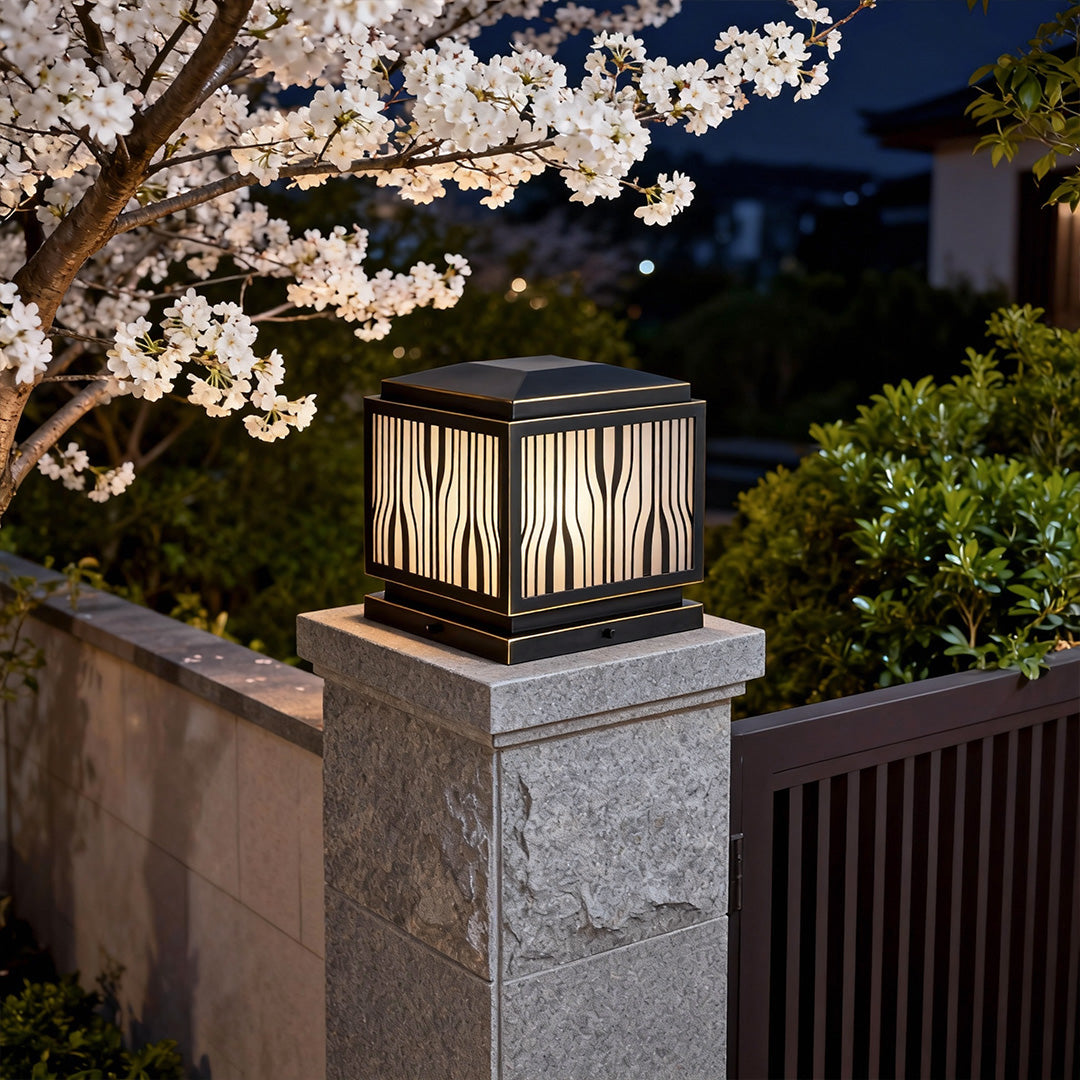 Stylish modern solar pillar lights casting a gentle glow on a garden wall during evening.