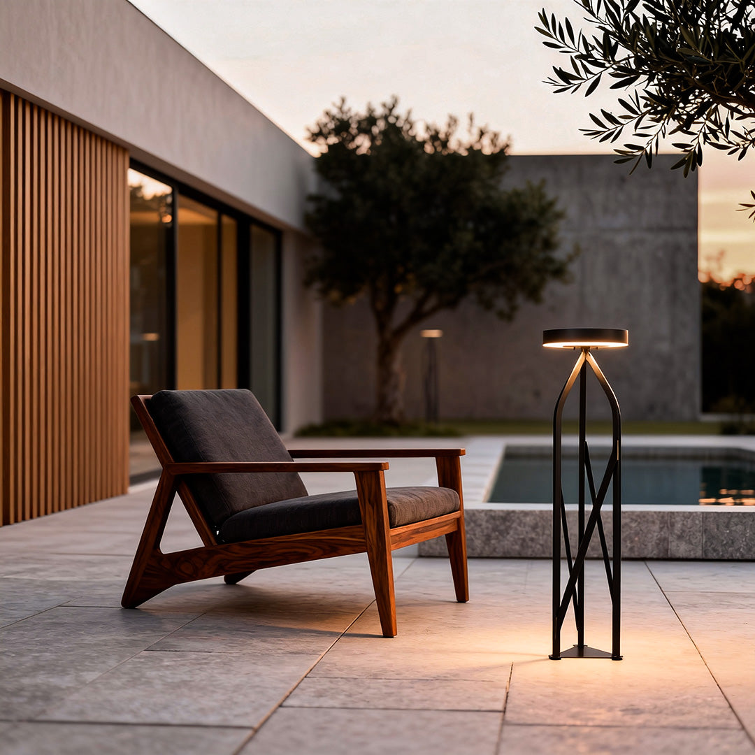 Stylish outdoor patio floor lamps illuminating a chic outdoor lounge with tables and chairs at dusk.