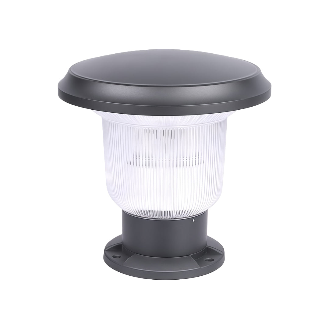 Stylish outdoor pillar light shining on a decorative fence at night.