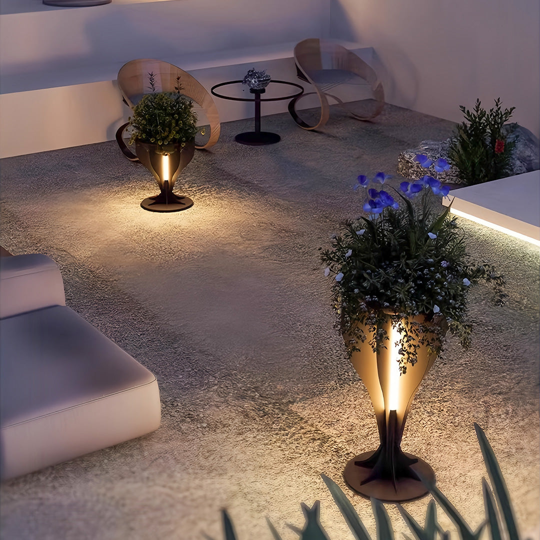Stylish outdoor patio scene at night using a lighted planter set for landscape illumination.