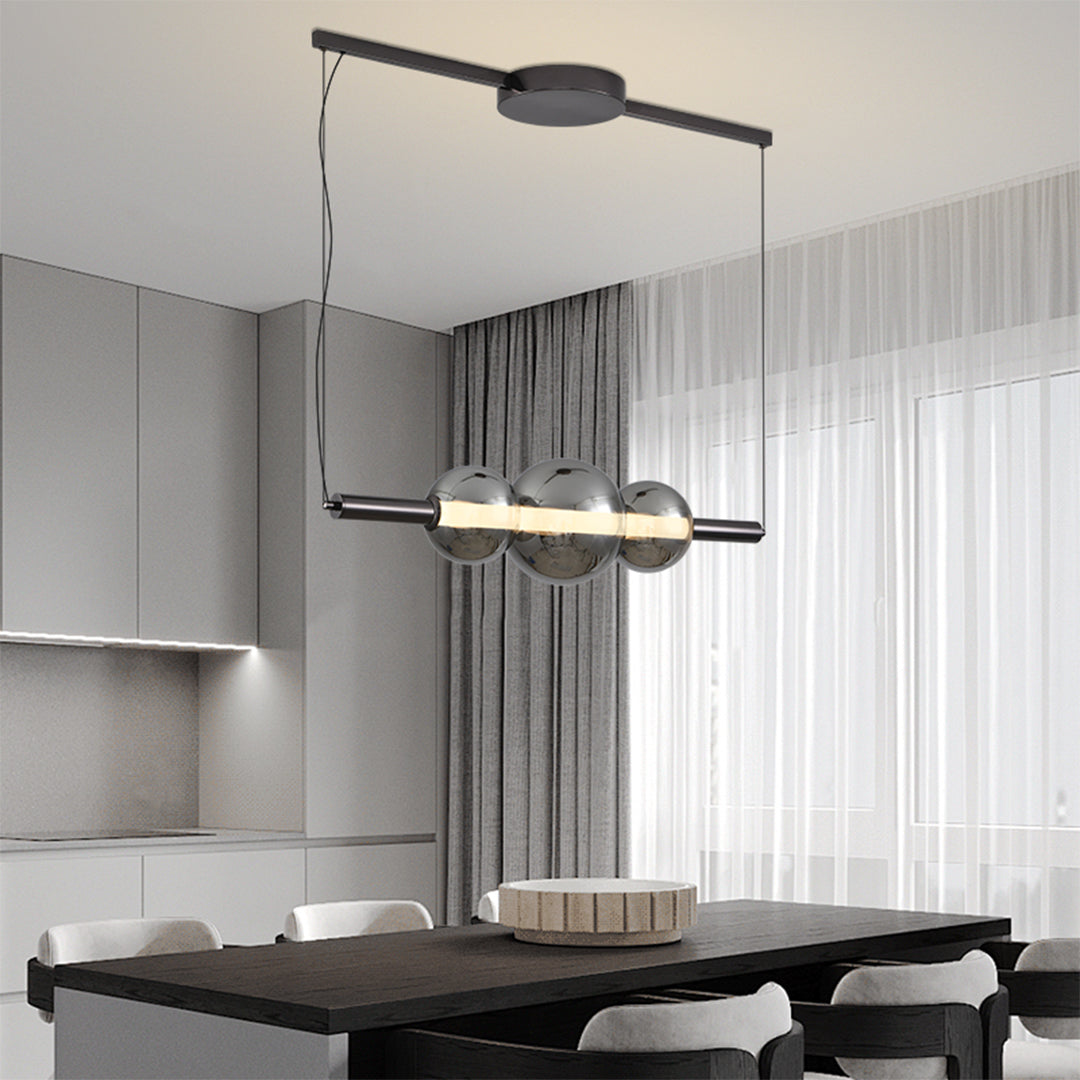 Stylish silver pendant light for kitchen island suspended over modern dining table in minimalist interior