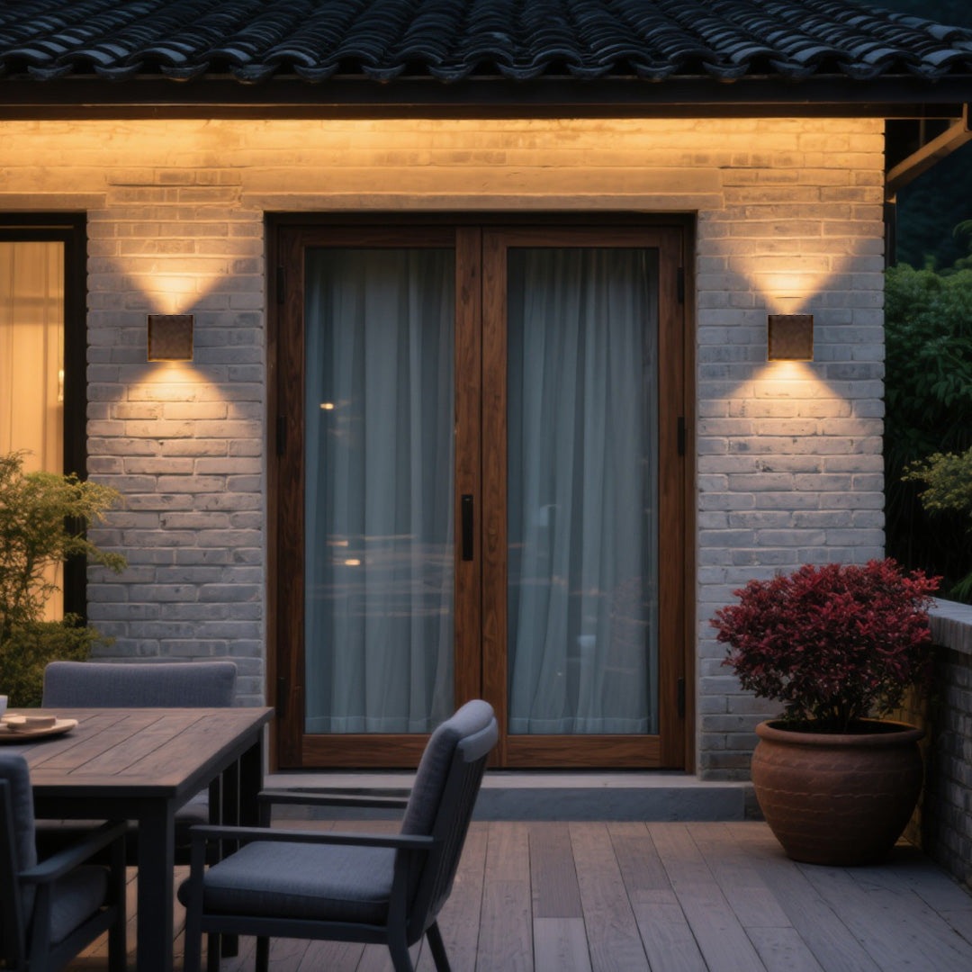 Terrace dining area lit by two stylish up-down Outdoor Wall Light Waterproof fixtures on a gray brick wall.