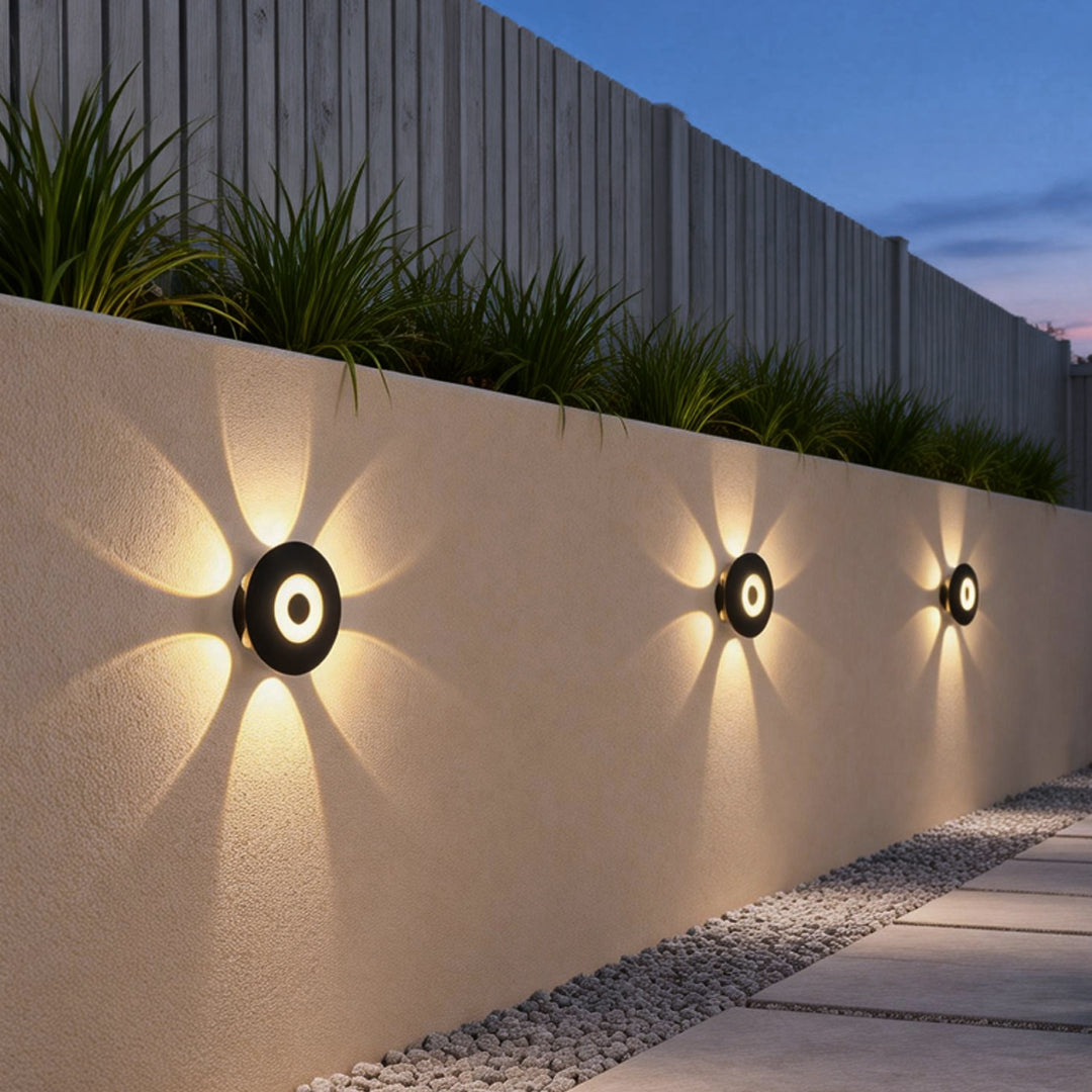 Sunflower LED wall light providing soft, directional light along a garden pathway.