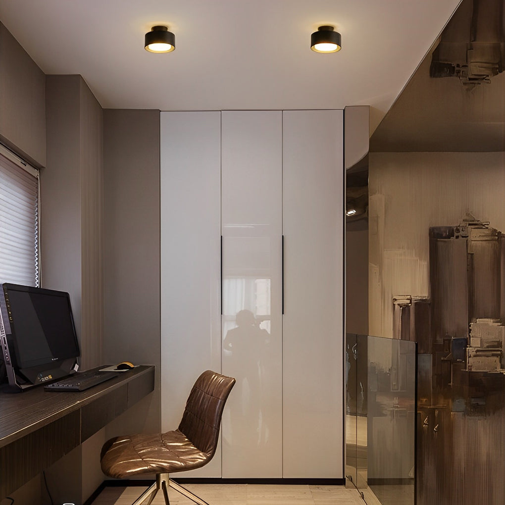 Surface mounted LED downlight casting warm light in a home office with a desk and chair.