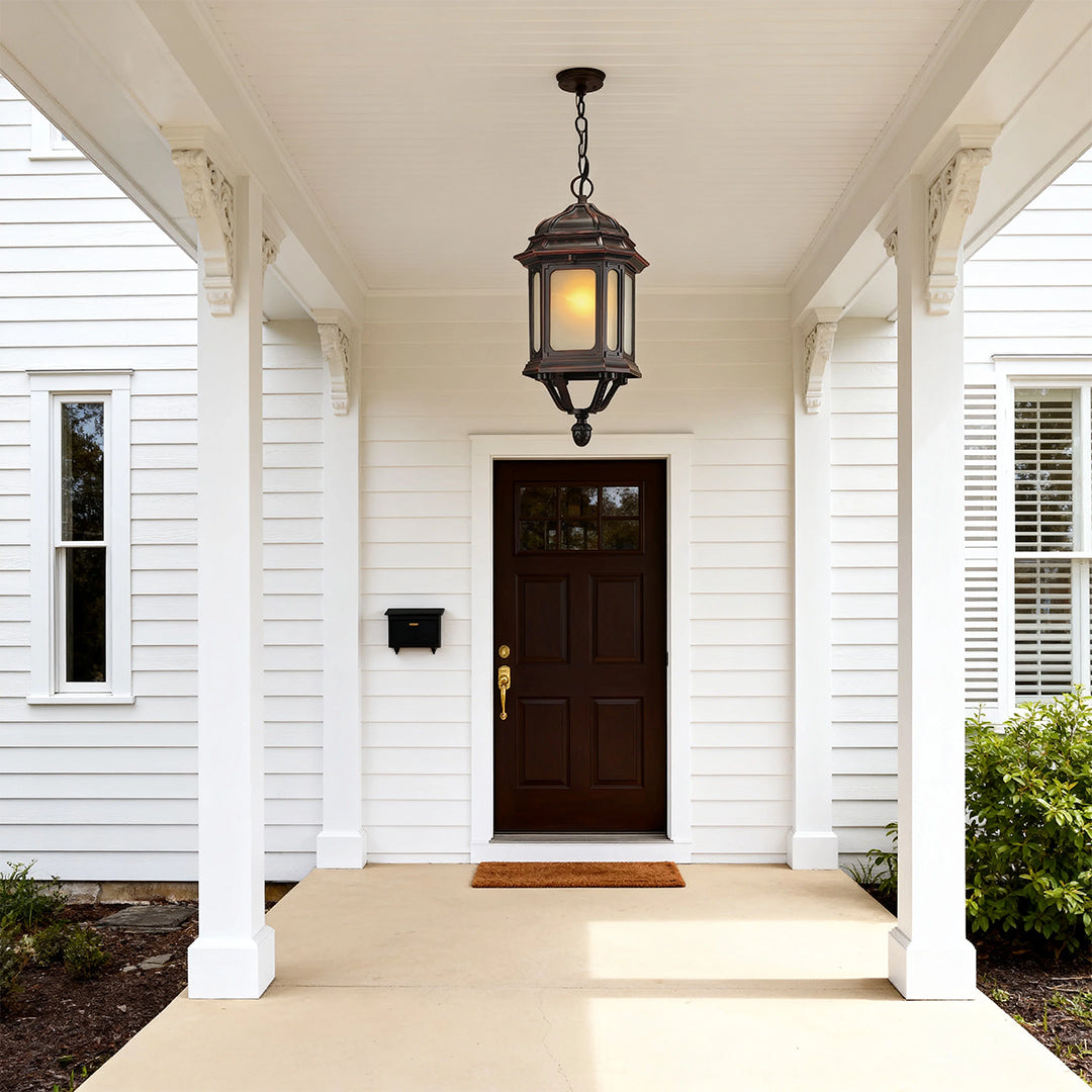 Suspended bollard LED light providing warm ambiance in bright covered entry walkway with brown door