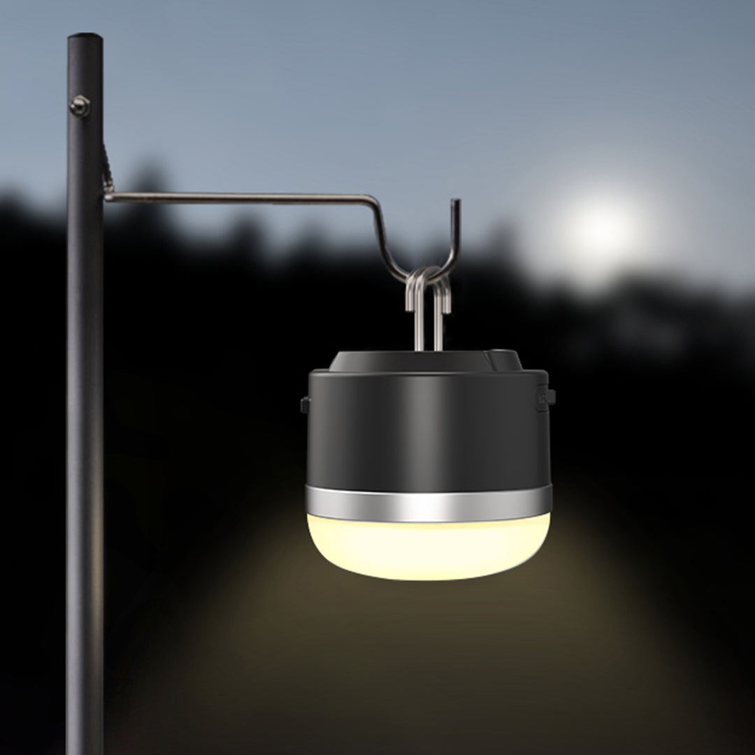 Suspended camp light creating ambient lighting for outdoor cooking and dining setup